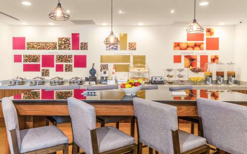 a kitchen with a counter with chairs and a table at Hampton Inn & Suites by Hilton Los Cabos in San José del Cabo