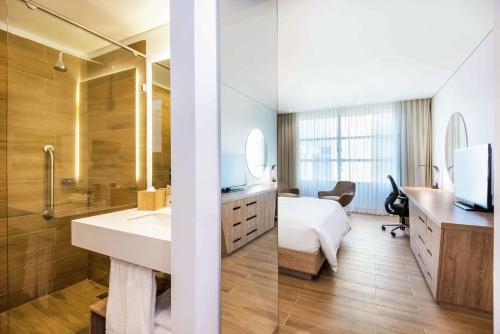 La salle de bains est pourvue d'un lit, d'un lavabo et d'un miroir. dans l'établissement Hilton Garden Inn Santa Marta, à Santa Marta