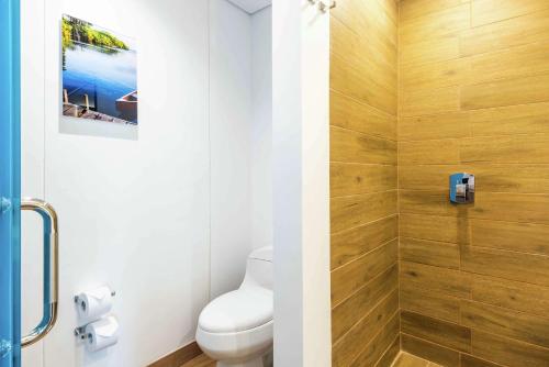 a bathroom with a toilet and a wooden wall at Hilton Garden Inn Santa Marta in Santa Marta