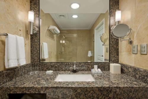 a bathroom with a sink and a large mirror at Hilton Garden Inn Tuxtla Gutierrez in Tuxtla Gutiérrez