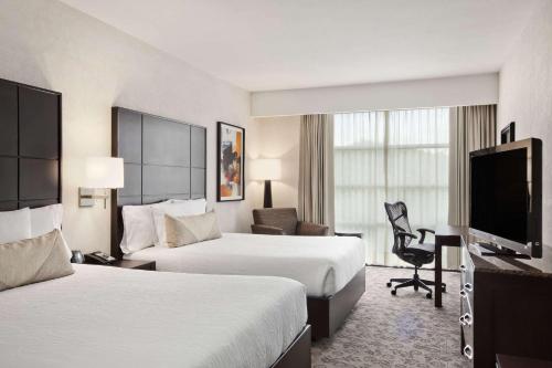a hotel room with two beds and a flat screen tv at Hilton Garden Inn Tuxtla Gutierrez in Tuxtla Gutiérrez