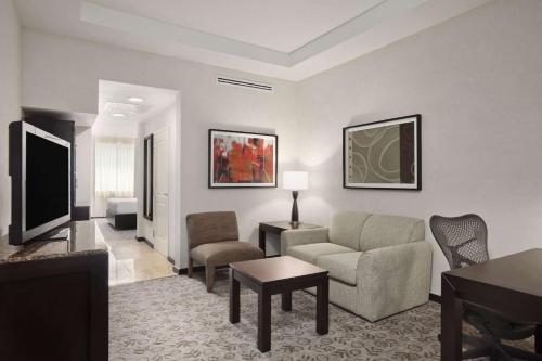 a living room with a couch and a tv at Hilton Garden Inn Tuxtla Gutierrez in Tuxtla Gutiérrez