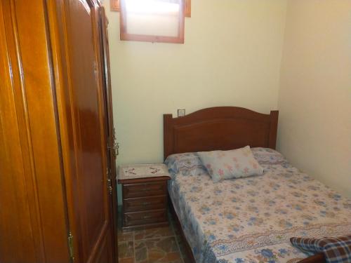 a small bedroom with a bed and a night stand at Dar Si Tawfik for Couples and Famillies in Chefchaouene