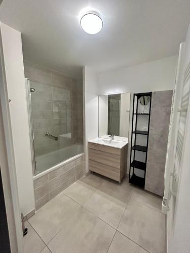 une salle de bain avec un lavabo, une baignoire et un miroir dans l'établissement BLUE PORT -4 étoiles-2 Loggias Vues-2 Parking, à Marseillan