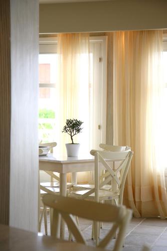 a table and chairs in a room with a window at Skopelos Village Hotel in Skopelos Town