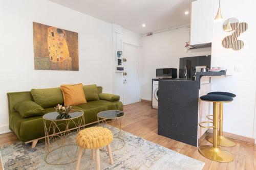 uma sala de estar com um sofá verde e uma cozinha em Parisian & Chic Appartement -15 min from Paris Center em Ivry-sur-Seine