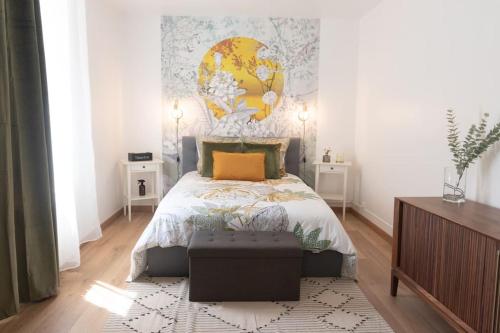 um quarto com uma cama com uma grande pintura na parede em Parisian & Chic Appartement -15 min from Paris Center em Ivry-sur-Seine