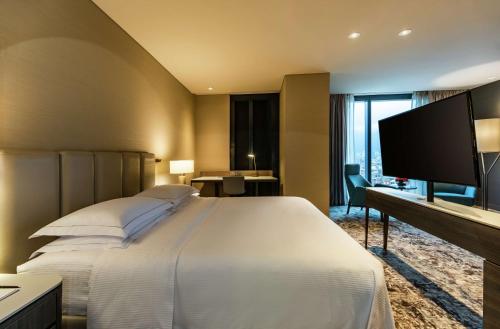 a hotel room with a large bed and a flat screen tv at Hilton Bogota Corferias in Bogotá