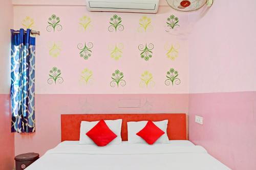 um quarto com uma cama com almofadas vermelhas em Flagship Star Guest House em Calcutá