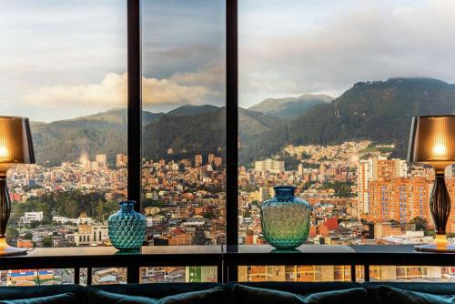 two vases sitting on a table in front of a window at Hilton Bogota Corferias in Bogotá