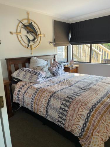 a bedroom with a bed and a window at Bach on Daisy in Tauranga