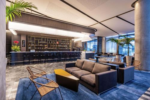 a lobby with a couch and a bar at Hilton Bogota Corferias in Bogotá