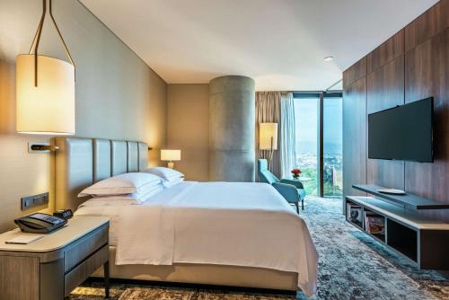 a hotel room with a bed and a television at Hilton Bogota Corferias in Bogotá