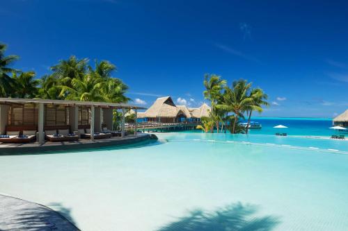a large swimming pool with the ocean in the background at Conrad Bora Bora Nui in Bora Bora