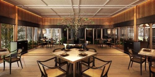a dining room with tables and chairs and windows at Conrad Bora Bora Nui in Bora Bora