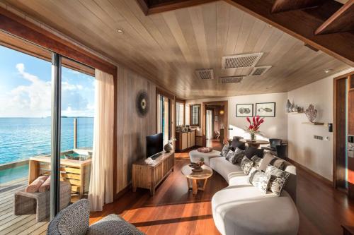a living room with a white couch and a view of the ocean at Conrad Bora Bora Nui in Bora Bora