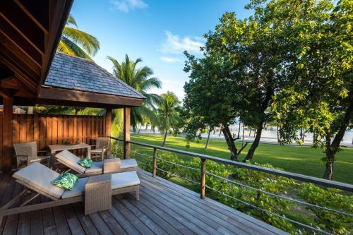a deck with chairs and tables on a house at Conrad Bora Bora Nui in Bora Bora