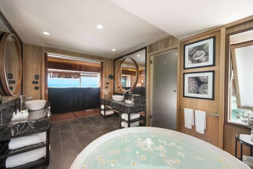 a bathroom with two sinks and a large tub at Conrad Bora Bora Nui in Bora Bora