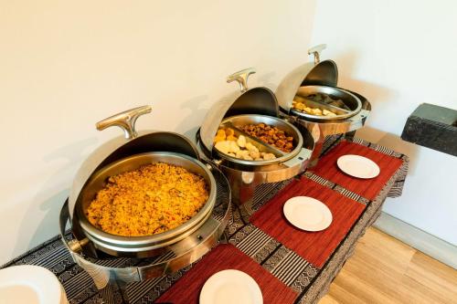 a group of four pots of food on a table at Hilton Garden Inn Barranquilla in Barranquilla