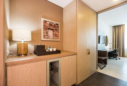a room with a desk with a lamp and a room at Hilton Garden Inn Barranquilla in Barranquilla