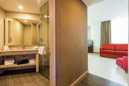 a hotel bathroom with a sink and a red couch at Hilton Garden Inn Barranquilla in Barranquilla