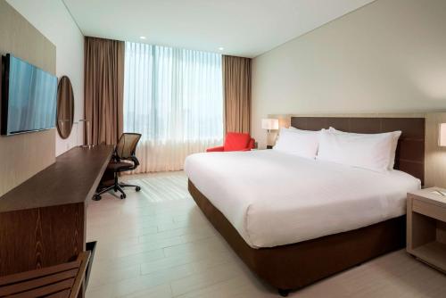 a hotel room with a large bed and a desk at Hilton Garden Inn Barranquilla in Barranquilla
