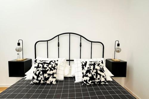 a bedroom with a black and white bed with pillows at Stay Well Home in Lisbon