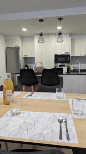 a wooden table with fork and spoon and a kitchen at Hydros in Ripoll