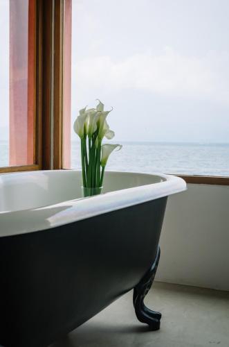 a bath tub with a vase with flowers in it at Anzan Atitlan in San Marcos La Laguna