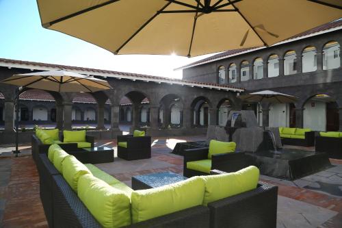 a patio with couches and tables and umbrellas at Hilton Garden Inn Cusco in Cusco
