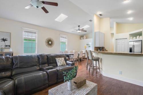 a living room with a leather couch and a kitchen at Jupiter's Beacon Villa in Jupiter