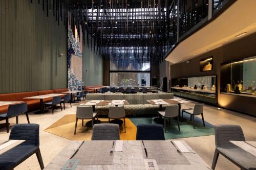 un restaurante con mesas y sillas en una habitación en Hilton Garden Inn Lima Miraflores, en Lima