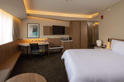 Cette chambre comprend un lit et un bureau. dans l'établissement Hilton Garden Inn Lima Miraflores, à Lima