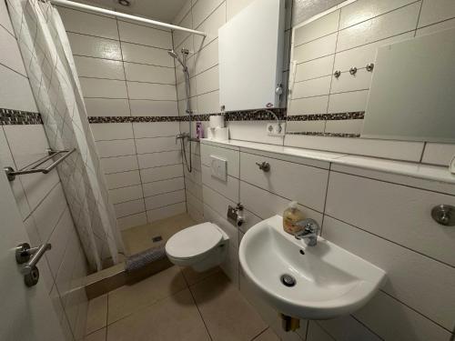 a bathroom with a sink and a toilet and a mirror at Best Cologne in Cologne