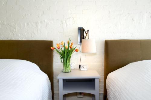 a vase of flowers on a table between two beds at Hotel on North in Pittsfield