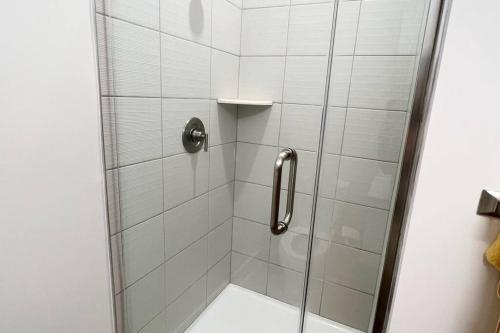 a shower stall with a glass door with a shower at Modern Queen Bed & Twin Futon Studio with WiFi, Kitchen, Washer, and Dryer in Charlotte