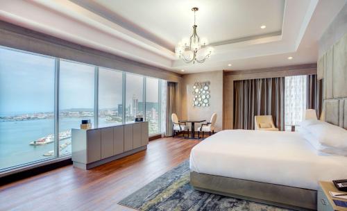 a bedroom with a large bed and a large window at Hilton Panama in Panama City