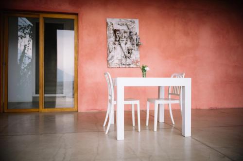a white table and chairs in a room with a wall at Anzan Atitlan in San Marcos La Laguna