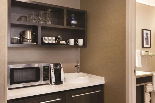 uma cozinha com um micro-ondas e um lavatório em DoubleTree by Hilton Hotel Boston - Downtown em Boston