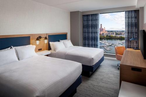 a hotel room with two beds and a window at Hampton Inn Boston Seaport District in Boston