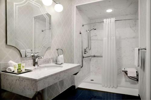 a white bathroom with a sink and a shower at The Drake Hotel in Chicago