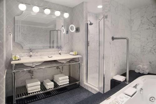 a bathroom with a sink and a shower and a tub at The Drake Hotel in Chicago