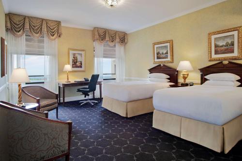 a hotel room with two beds and a desk at The Drake Hotel in Chicago