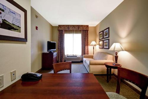 a hotel room with a table and a living room at Homewood Suites by Hilton Charleston Airport/Convention Center in Charleston