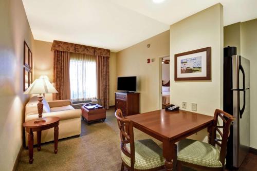 a hotel room with a table and a living room at Homewood Suites by Hilton Charleston Airport/Convention Center in Charleston