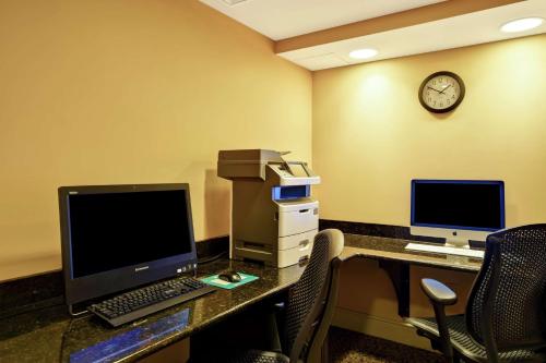 an office with a desk with a computer and a clock at Homewood Suites by Hilton Charleston Airport/Convention Center in Charleston