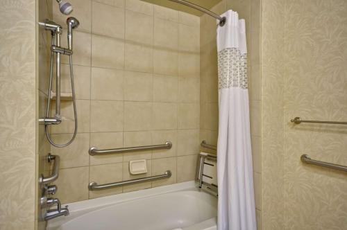 a bathroom with a tub and a shower with a shower curtain at Hampton Inn & Suites North Charleston-University Boulevard in Charleston