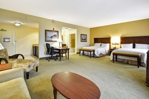a hotel room with two beds and a living room at Hampton Inn & Suites North Charleston-University Boulevard in Charleston