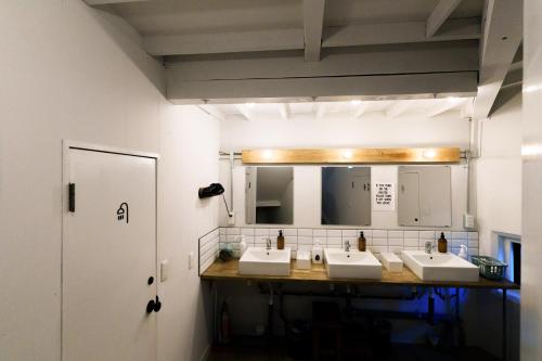 a bathroom with three sinks and a mirror at 野沢温泉ロッヂ in Nozawa Onsen