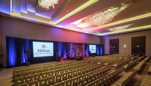 a hall with chairs and a screen with a presentation at Hilton Dallas/Plano Granite Park in Plano